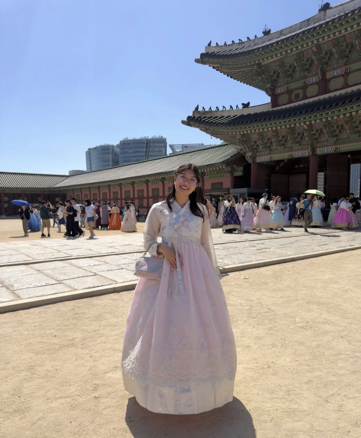 Tourists on a guided English tour inside Gyeongbokgung Palace listening to a local expert explain the throne hall